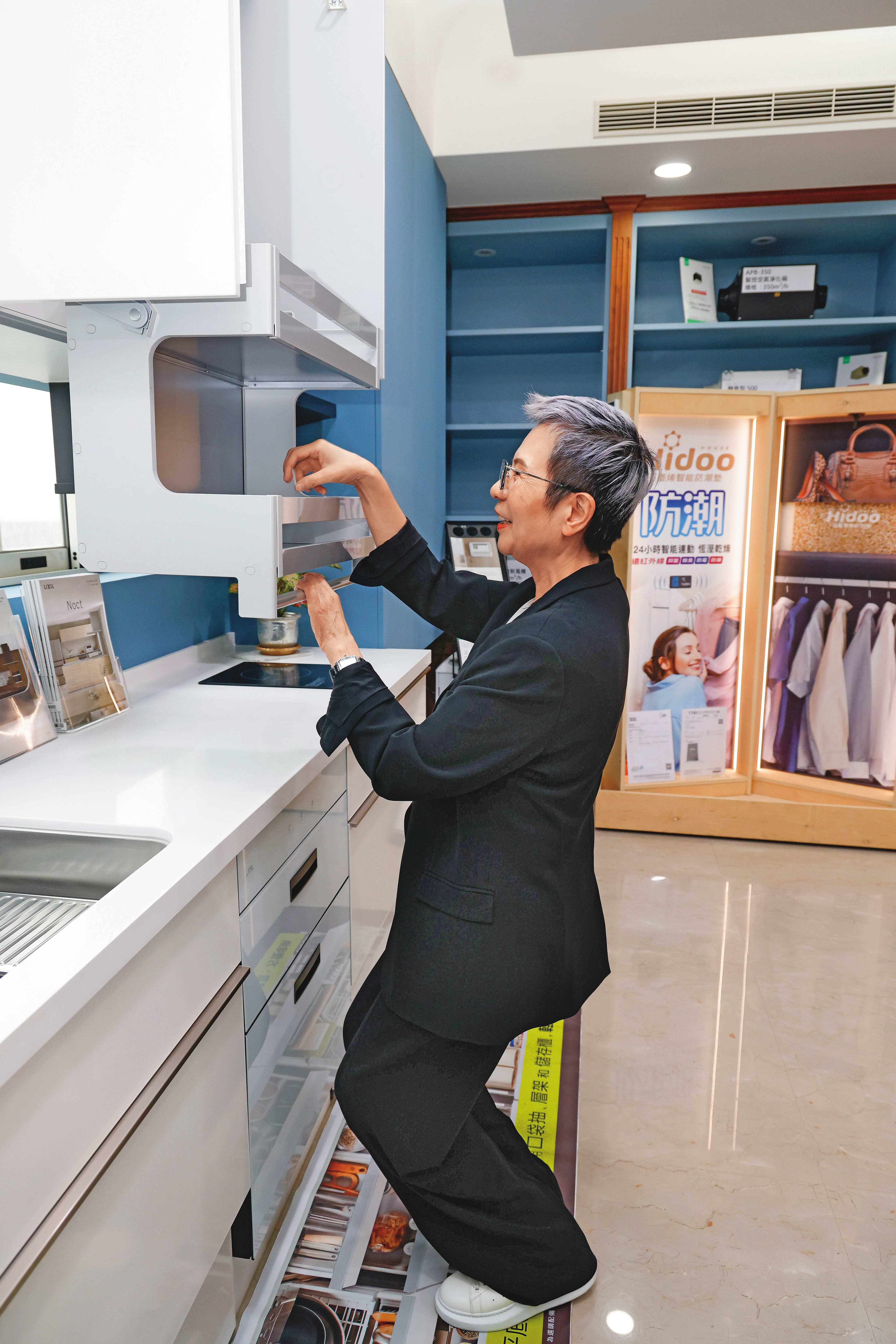 曾婷婷代理日本LIXIL樂齡廚具,她示範即使坐在輪椅上,也可輕易下拉櫃子。